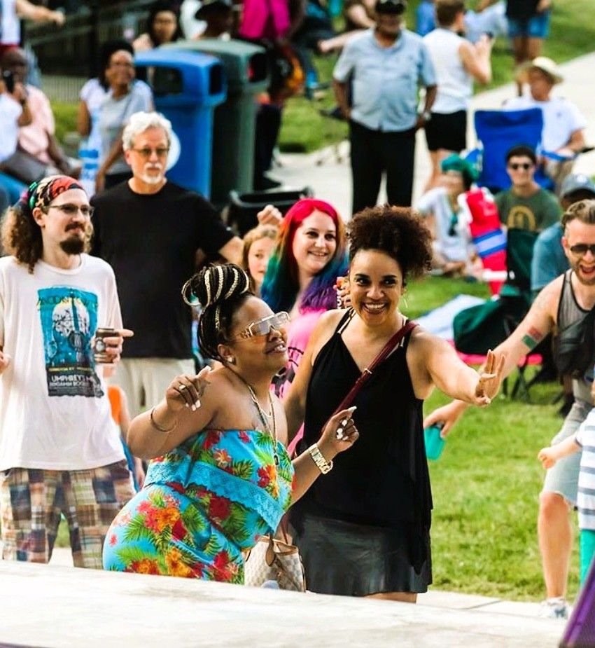 Neighbors dancing together on the lawn at a free outdoor concert