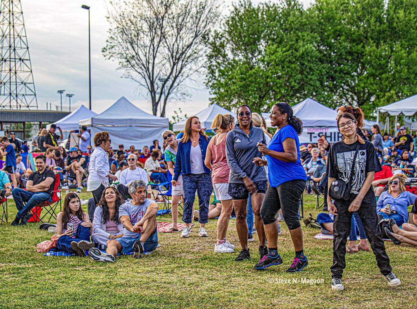 Neighbors dancing on the lawn at MusicFest, with the Gasmer derrick in the distance