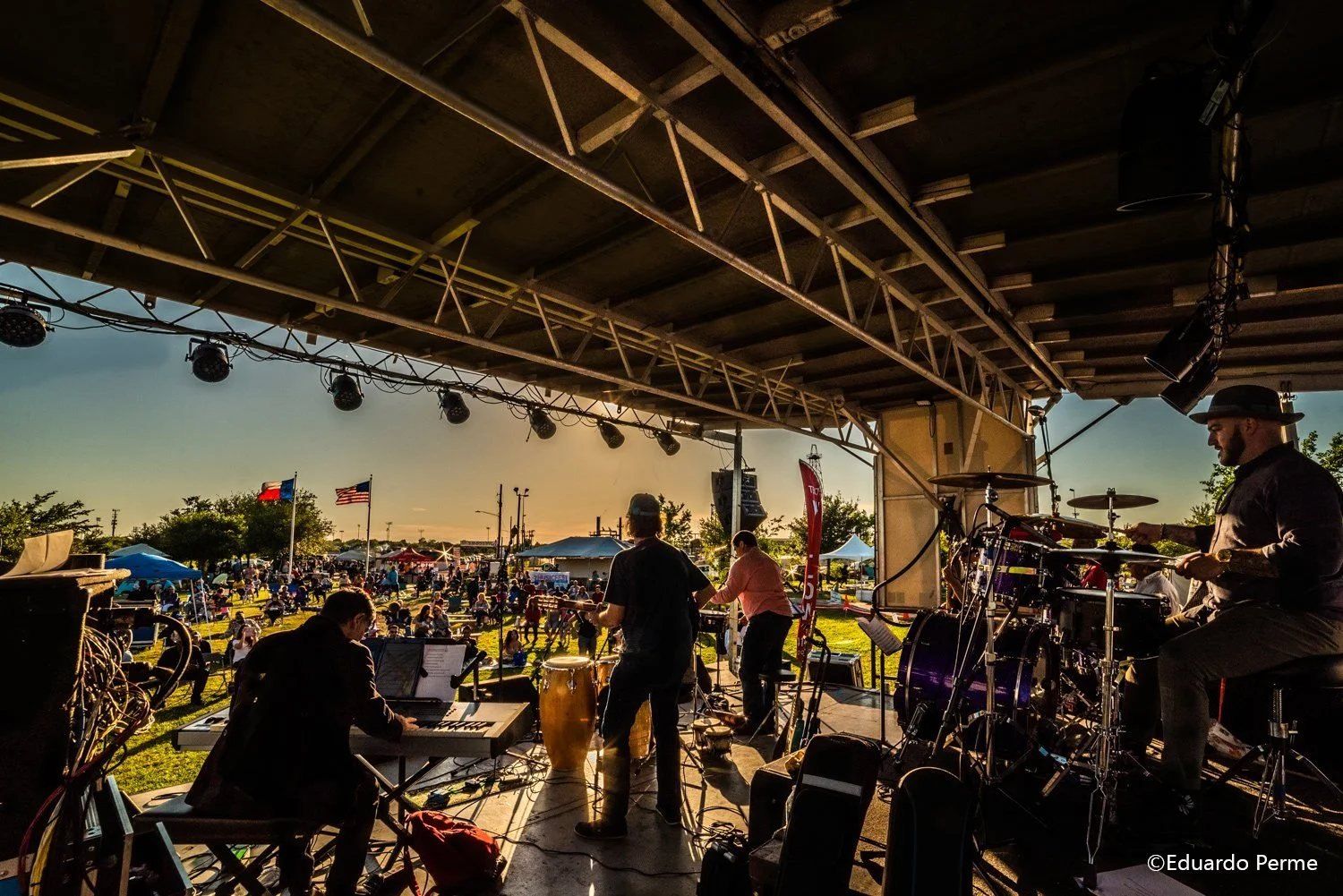 A band on the MusicFest stage at sunset, playing to a crowd on the lawn at Willow Waterhole