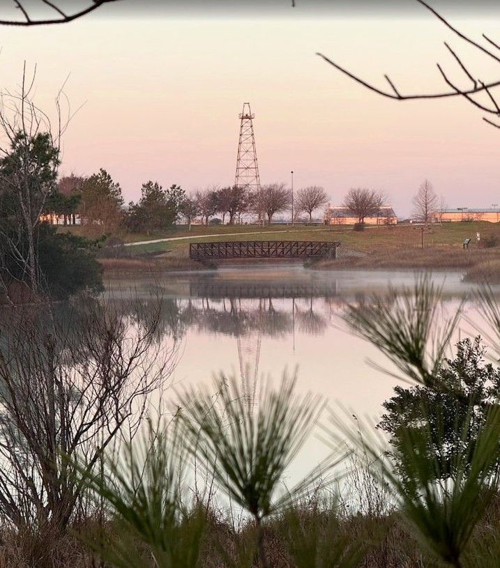 The historic Gasmer oil derrick seen across a lake at Willow Waterhole at dusk