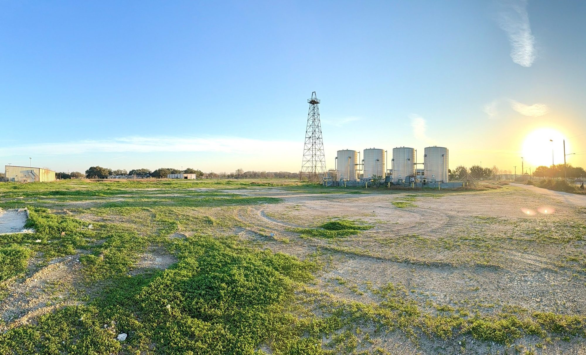 Morning light over the former Shell Gasmer property, with the historic derrick and white storage tanks on the horizon